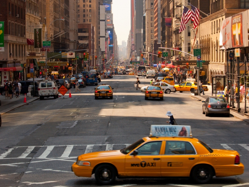 City street scene with yellow cab in foreground